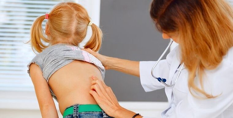 médico examinando la espalda de un niño para detectar dolor de espalda